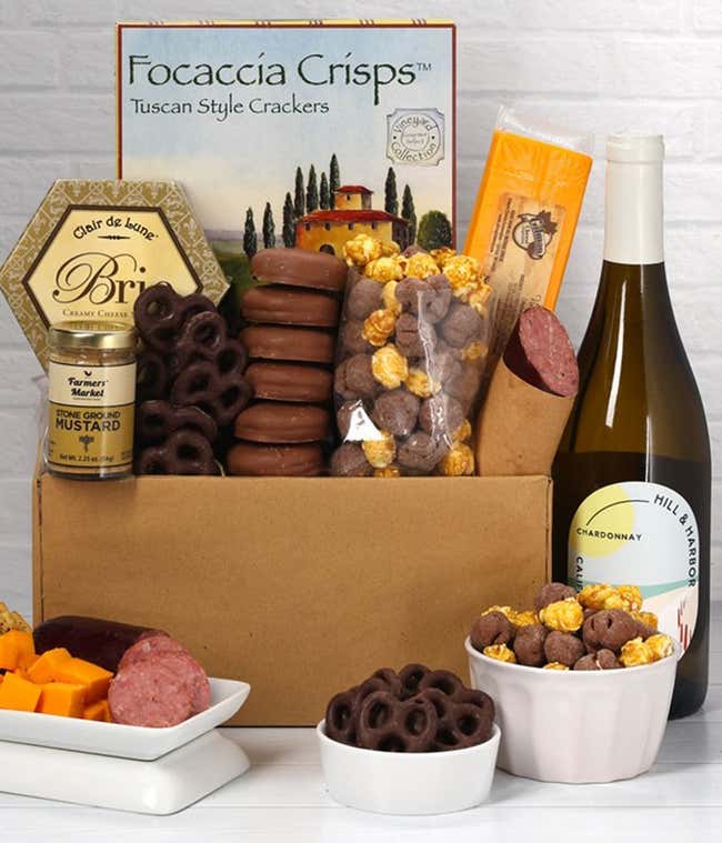A gift set featuring a bottle of Hill &amp; Harbor Chardonnay, focaccia crisps, 2 cheeses, mustard, summer sausage, caramel popcorn, chocolate pretzels, and 6 chocolate-covered Oreos for a sweet and savory gourmet experience.