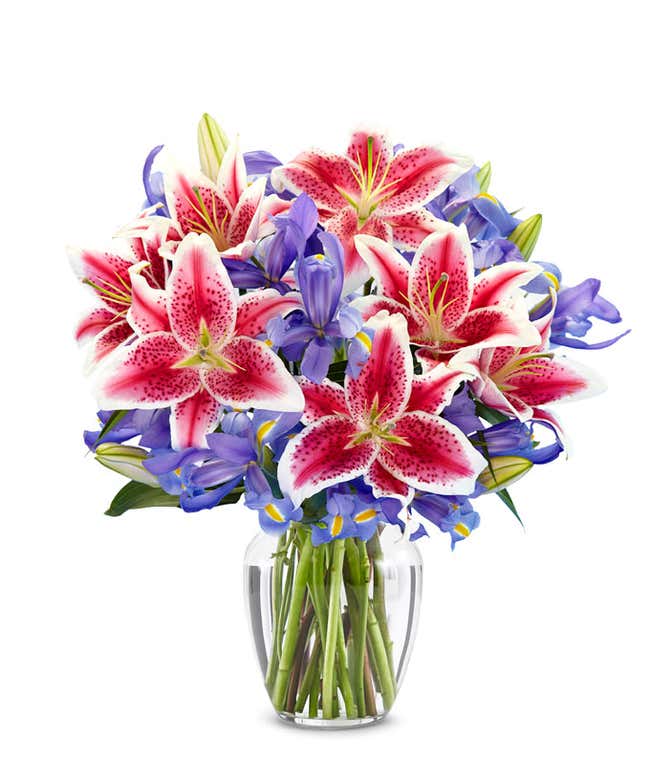 A bouquet of Iris &amp; Stargazer Lilies in a Glass Vase