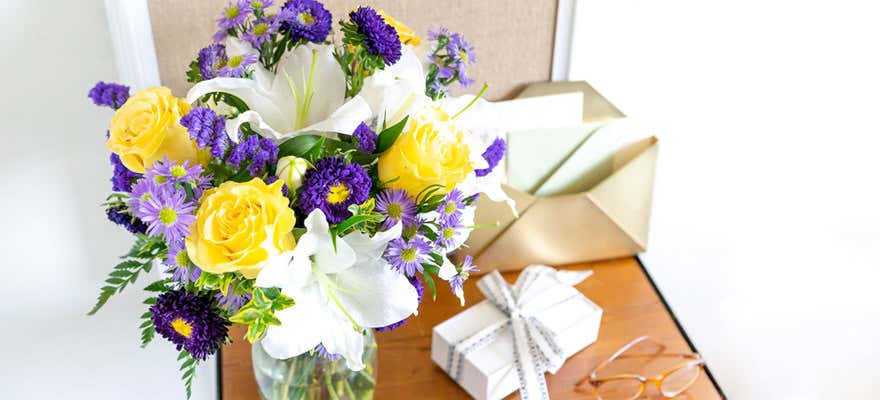 Blue and yellow bouquet on a table with a small present