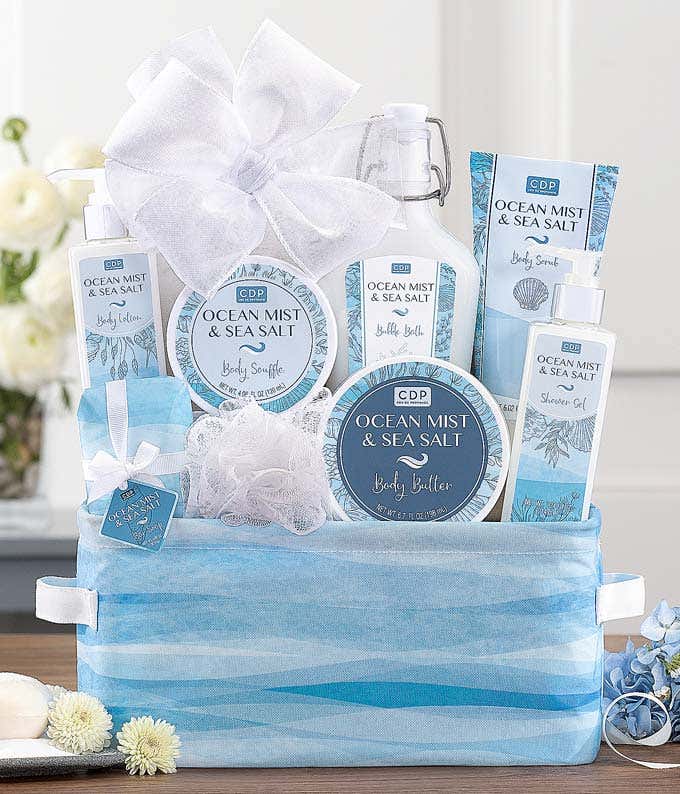 Ocean Mist & Sea Salt gift set displayed in a blue and white patterned basket, featuring body lotion, body butter, shower gel, bath salts, a body soufflé, and a mesh sponge